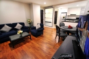 The living room has ample space and is equipped with a sofa set and a large flat screen LCD television